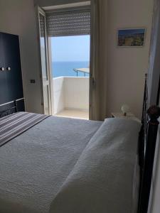 佩斯基奇Hotel Peschici的一间卧室配有一张床,享有海景