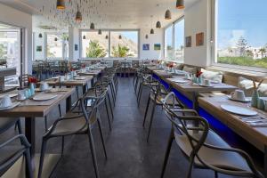 佩里萨Kouros Village Hotel - Adults Only的餐厅里一排桌椅