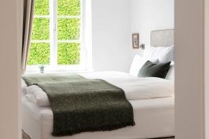 因斯布鲁克Quartier 99的卧室配有白色的床和绿毯
