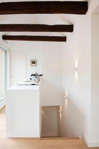 因斯布鲁克Quartier 99的白色的厨房设有白色的柜台和木制天花板。