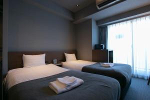 东京Minn Ueno的酒店客房设有两张床和窗户。