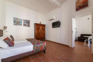 罗马Appartamento Via Genova的一间卧室配有一张床、一台电视和一张沙发