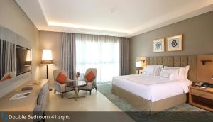 迪拜Grand Cosmopolitan Hotel的配有一张床和一张书桌的酒店客房