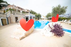 维耶斯泰伊尔法尔科公寓式酒店的两个红心坐在游泳池旁的岩石上