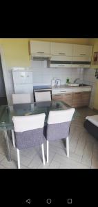 希贝尼克日落公寓的厨房配有玻璃桌和两把椅子