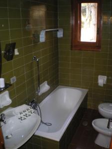 斯坎诺Residence I Comignoli的绿色瓷砖浴室设有浴缸和水槽