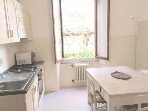 蒙特卡蒂尼泰尔梅普契尼别墅度假屋的厨房配有水槽、桌子和窗户