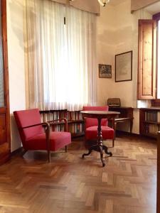 蒙特卡蒂尼泰尔梅普契尼别墅度假屋的一个带红色椅子和桌子的图书馆和一个窗口