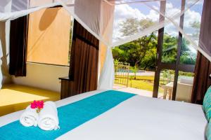 卡萨内Wild View Resort的一间卧室配有带毛巾的床和窗户。