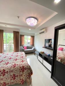 乔木提恩海滩Beach 7 Condo, Pattaya的一间卧室配有一张床、一台电视和一张沙发