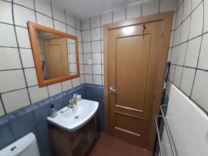 别尔萨Apartamento en Pirineos的一间带水槽、卫生间和镜子的浴室