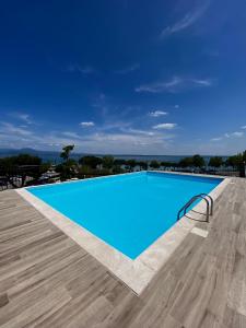 西尔米奥奈Alevic Hotel Sirmione的一座大型蓝色游泳池,位于一座建筑的顶部