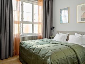 哥本哈根Rosenborg Hotel Apartments的一间卧室设有一张床和一个大窗户