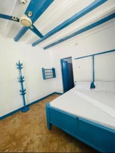 帕杰Beach House Paje的一间位于客房内的卧室,配有蓝色和白色的床