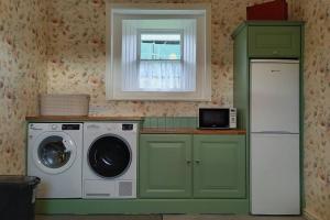 Suir Valley Cottage.的厨房配有洗衣机和窗户。