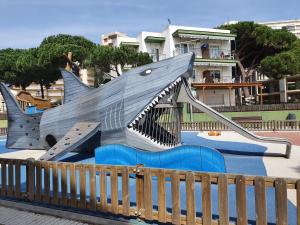 普拉加德阿罗Apartaments Les Roques的公园里一个带鲨鱼形滑梯的游乐场
