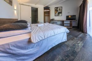 Saint-Aignan-de-Cramesnil拉杰勒斯酒店的一间卧室配有两张床和一台平面电视