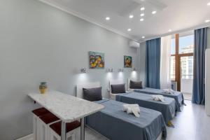 巴库Leyla Apartments 2的一间设有三张床的房间,内设一张桌子