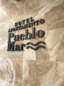 卡尔佩Hotel Apartamentos Pueblo Mar的酒店入口的标志