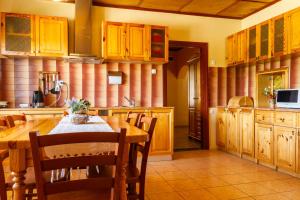 DruvaViesu nams Sidrabi的厨房配有木制橱柜和桌椅