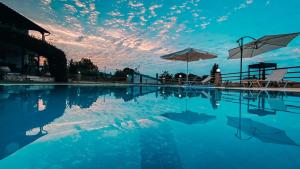 克里皮吉达芙妮别墅 的一个带遮阳伞的游泳池,天空中