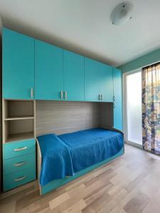 佩尔吉内瓦尔苏加纳ReBrì Holiday Home - appartamento Canale di Pergine的一间卧室配有蓝色橱柜和蓝色的床