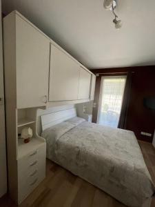 佩尔吉内瓦尔苏加纳ReBrì Holiday Home - appartamento Canale di Pergine的一间卧室配有一张带白色橱柜的床和窗户。