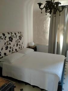 蒙德拉戈内Hotel & Resort Lunatenuta的卧室配有白色的床和窗户。