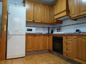 格拉纳达Los Jazmines, 2的厨房配有白色冰箱和木制橱柜。