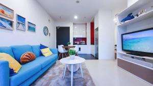 吉隆坡Mont Kiara, Arcoris W chilled balcony and TV Box, BeachHolidayHome的客厅配有蓝色的沙发和桌子