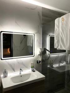 地拉那Jata Crown Hotel的白色的浴室设有水槽和镜子
