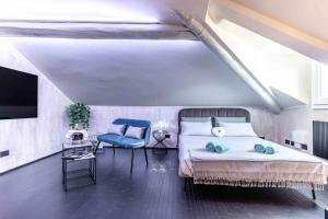 米兰VIA DELLA SPIGA N50 - Luxury Loft in the Heart of the Fashion District的一间卧室配有一张床、一台电视和一把椅子