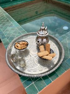 马拉喀什RIAD ENNAFOURA BOUTIQUE HOTEL的茶壶和茶几的托盘