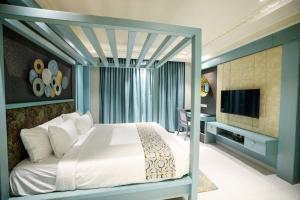 门格洛尔AJ Grand Hotel的一间卧室配有一张床、一台电视和一张书桌