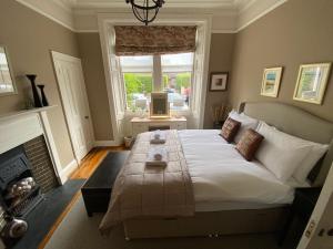 爱丁堡Braid Rd Stunning Villa的一间卧室设有一张大床和一个壁炉