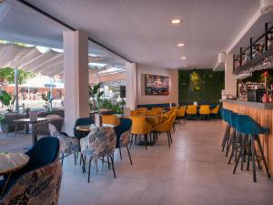 马盖鲁夫INN Mallorca Aparthotel的一间带桌椅的餐厅和一间酒吧