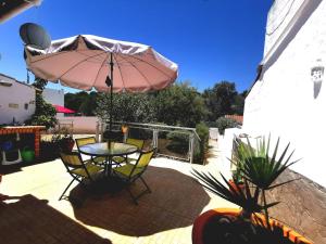 西尔韦斯Silves Country Room的一个带桌子和遮阳伞的庭院