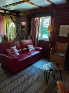 Comblain-FaironChalet des pins d'Autriche的客厅配有红色的沙发和桌子