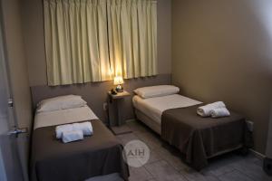 圣胡安Hotel Alhambra的酒店客房设有两张床和窗户。