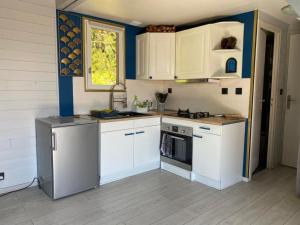梅尔维尔弗朗瑟维尔普拉格Le chalet Normand的厨房配有白色橱柜和炉灶烤箱。