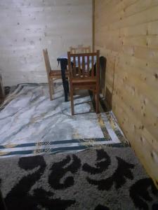 瓦勒博内Guesthouse Dioni的一间设有两张木椅和地毯的房间
