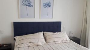 埃斯特角城Green Park的一张带蓝色床头板和两个白色枕头的床