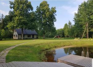ValtinaVäike-Puusmetsa puhkemaja的享有房屋和池塘的景色,设有游乐场
