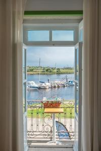 孔迪镇Naval Guest House & Bistrô的客房设有带桌子的窗户,水中设有船只