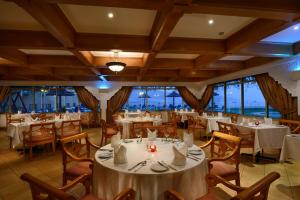 海塞卜阿塔那海塞卜酒店的餐厅设有白色的桌椅和窗户。