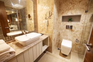 门格洛尔AJ Grand Hotel的一间带水槽、卫生间和镜子的浴室