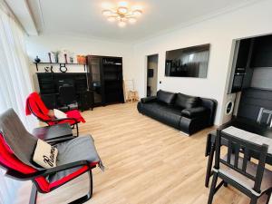布鲁塞尔Residential area - quiet place的客厅配有黑色沙发和椅子