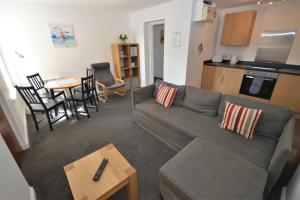 托伯莫里Puffin Apartment的带沙发和桌子的客厅以及厨房。