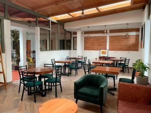 科万Matalbatz Hotel的餐厅设有木桌和绿色椅子