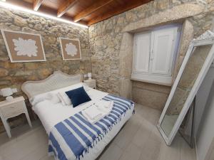 穆希亚Casa María的一间卧室设有一张床和石墙